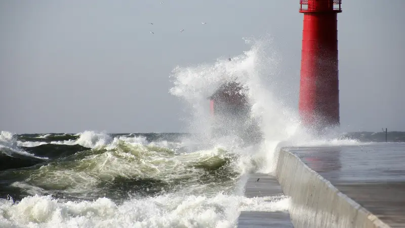 Onde che si infrangono su un faro rosso in tempesta